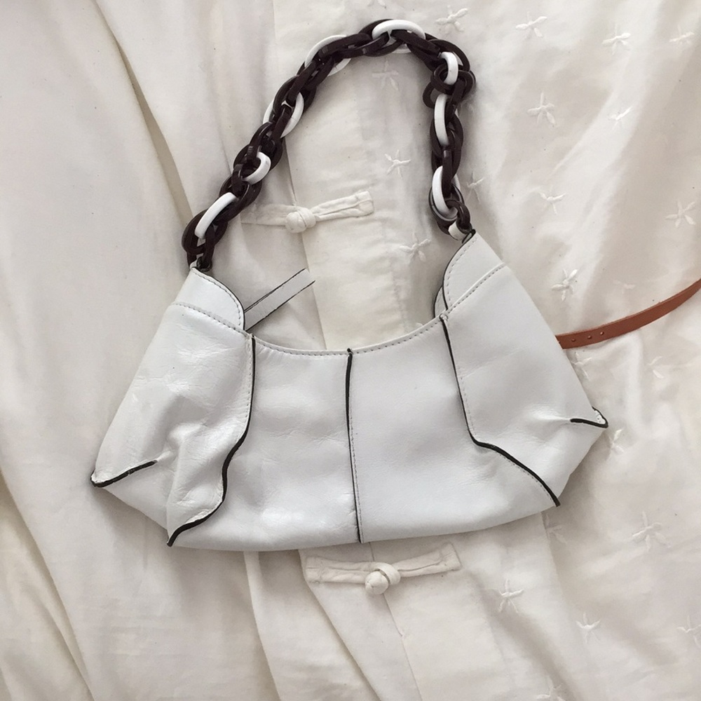 White leather bag with brown accents and chain